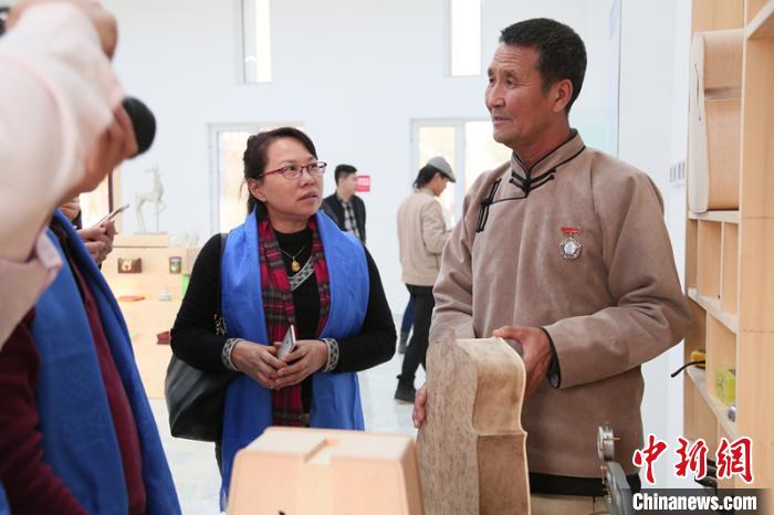 图为乌力吉(右)为来访嘉宾介绍马头琴。受访者供图 图为乌力吉(右)为来访嘉宾介绍马头琴。受访者供图