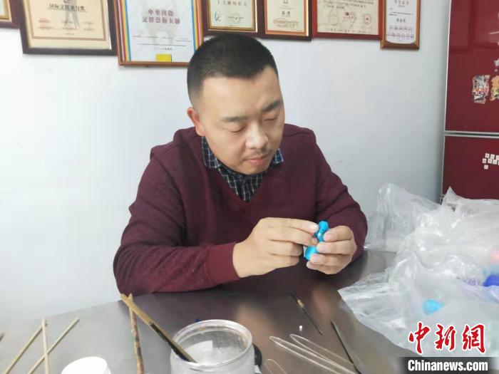 山西浮山面塑艺术传承人卫兴安正在做面塑。 杨佩佩 摄