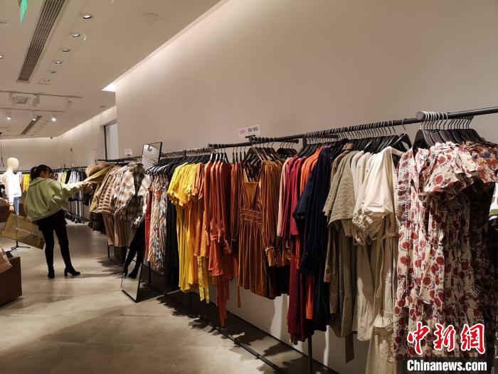一位女性正在挑选衣服。 唐小晴 摄 一位女性正在挑选衣服。 唐小晴 摄