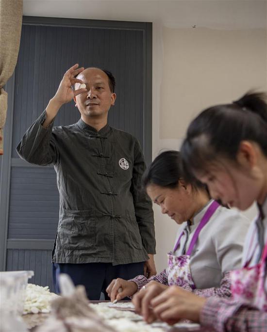 李国伟在云南保山市永子棋厂检查制作好的永子（5月12日摄）。 