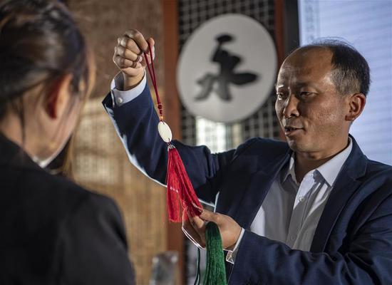 李国伟向顾客推荐利用永子制作的文创产品（5月12日摄）。