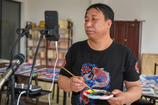 6月25日，在梨树县孤家子镇，农民画传承人钱洪满在直播授课。