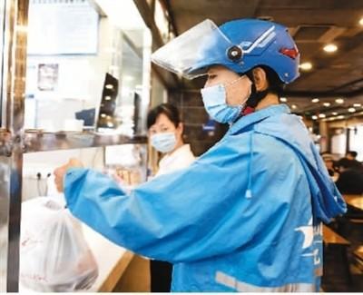 来自四川省凉山彝族自治州的网约配送员邱有哈子在成都市一家餐厅取餐。 新华社记者 李梦馨摄
