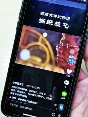  撕纸技艺传承人华兴富在用短视频展示制作技艺。本报记者 董蓓摄/光明图片